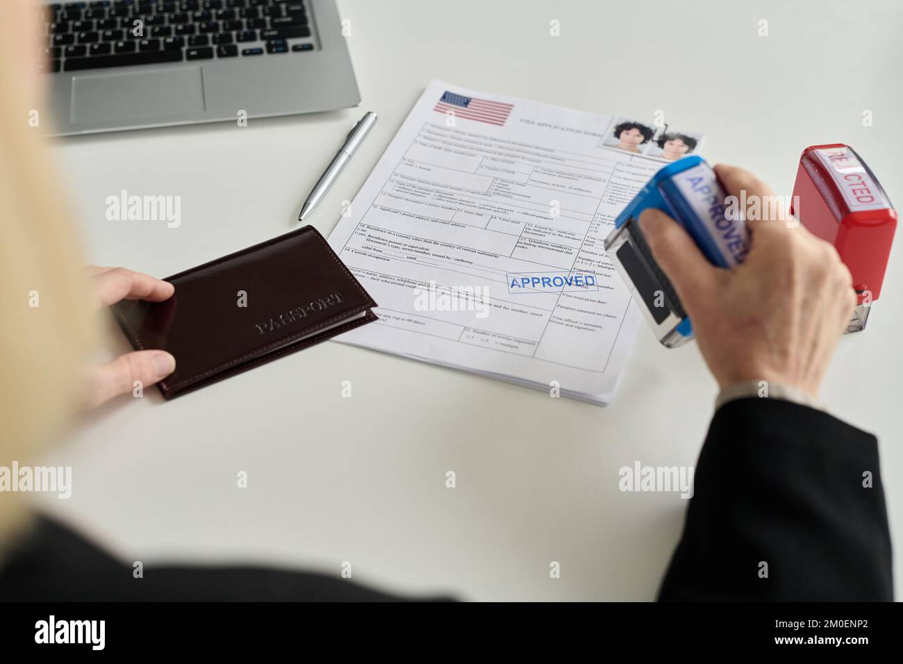 Close up of immigration office worker approving visa application for Caucasian young woman Stock Photo