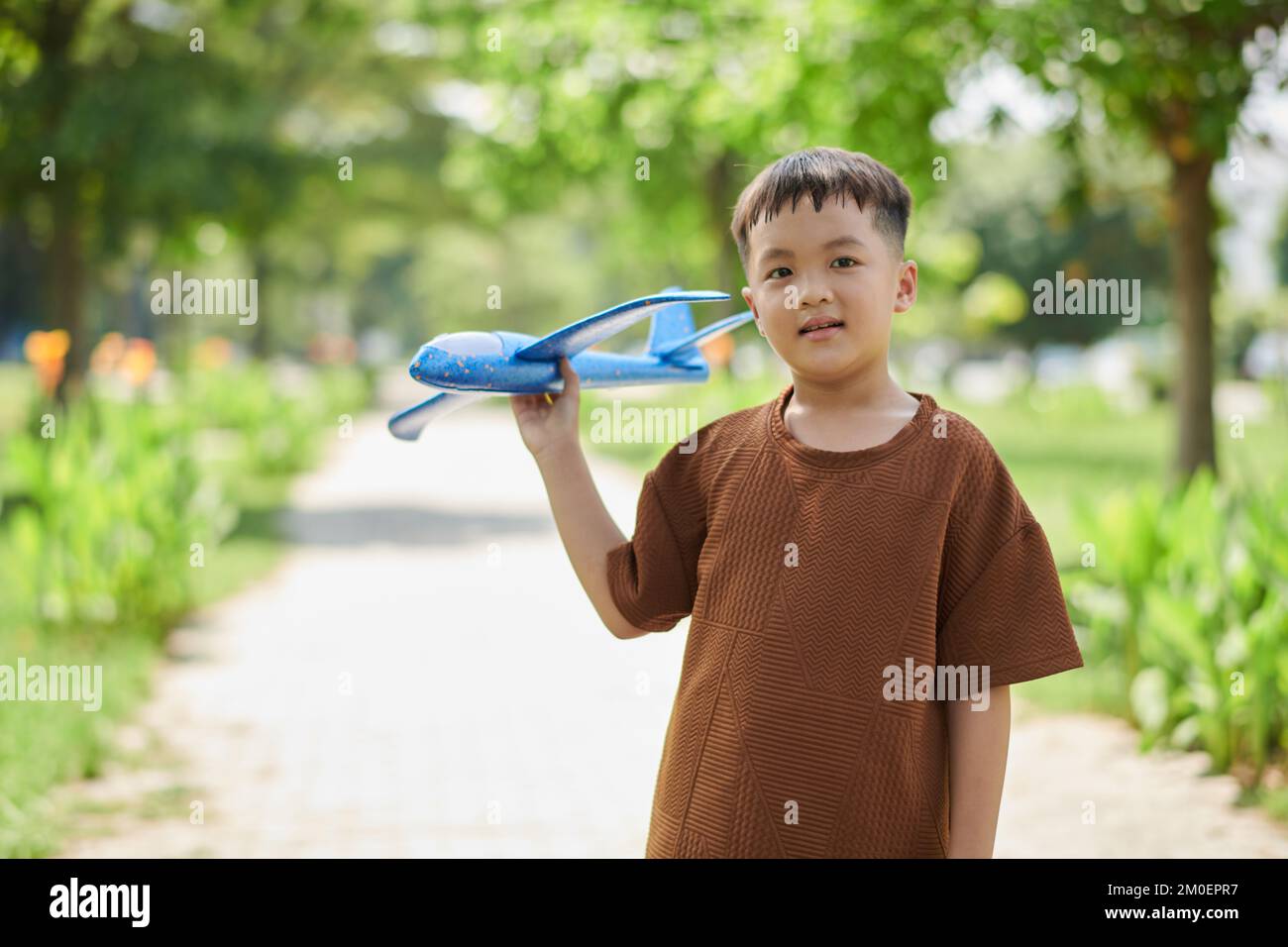 Portrait of preteen boy playing with toy plane in city park Stock Photo ...