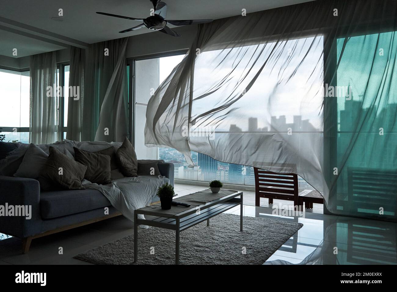 The Wind Rustles The wind rustles the curtain of the panoramic window with a cityscape ...