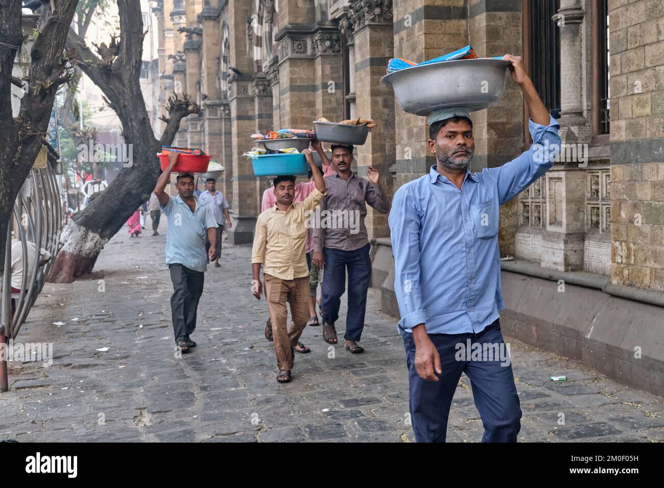 Porters with trays of fish on their heads, outside Chhatrapati Shivaji Maharaj Terminus (CMST), in Mumbai, India, to forward the trays by train Stock Photo