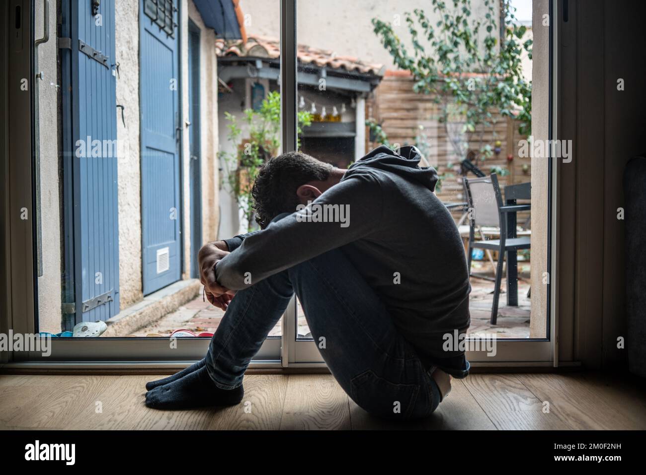 Depressed man. Sad unhappy Man sitting on the floor and holding his ...
