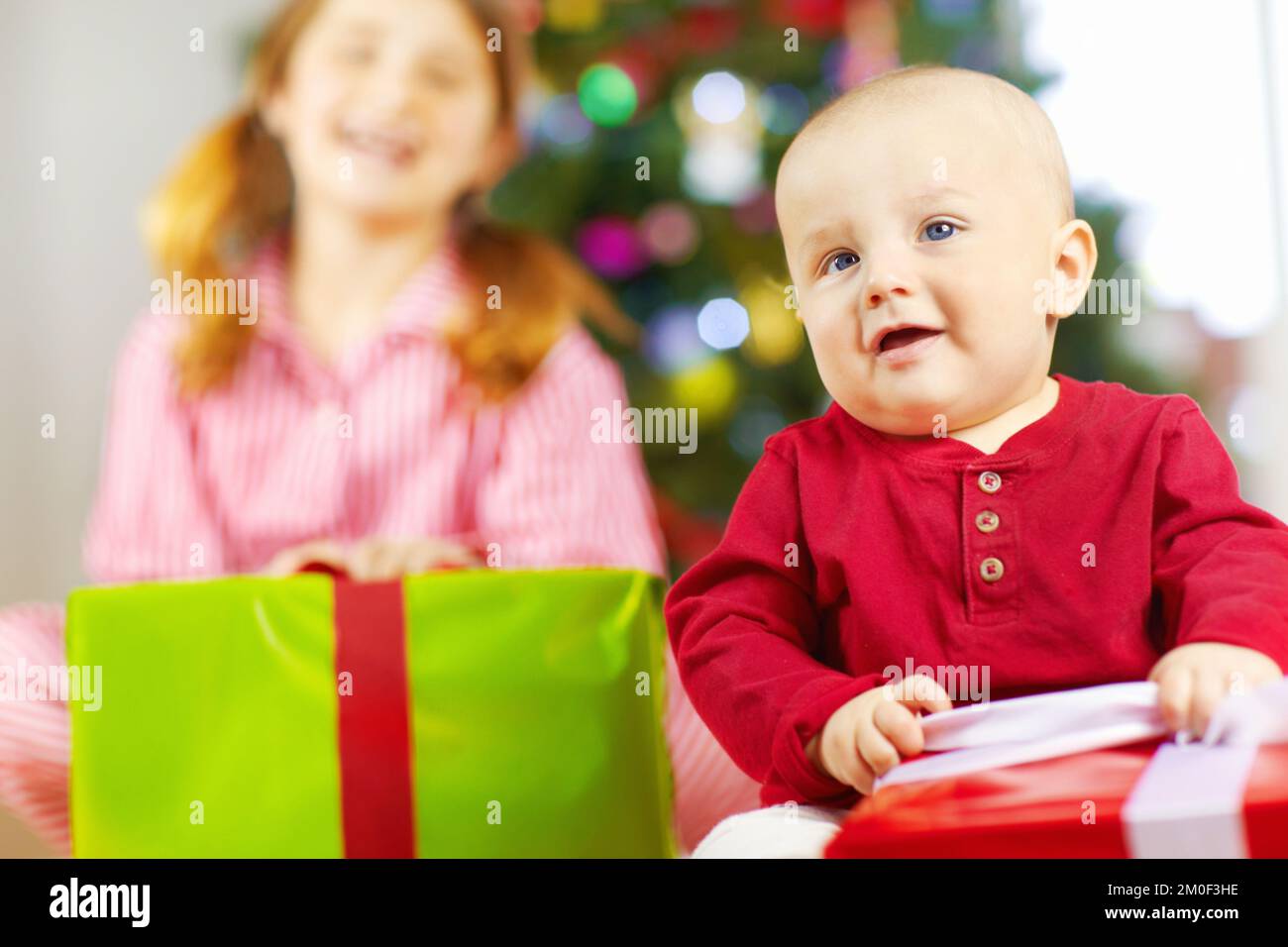 Christmas, boy and baby with gift for celebration, festive season or happy. Children, male child or sister enjoy presents, happiness and vacation for Stock Photo