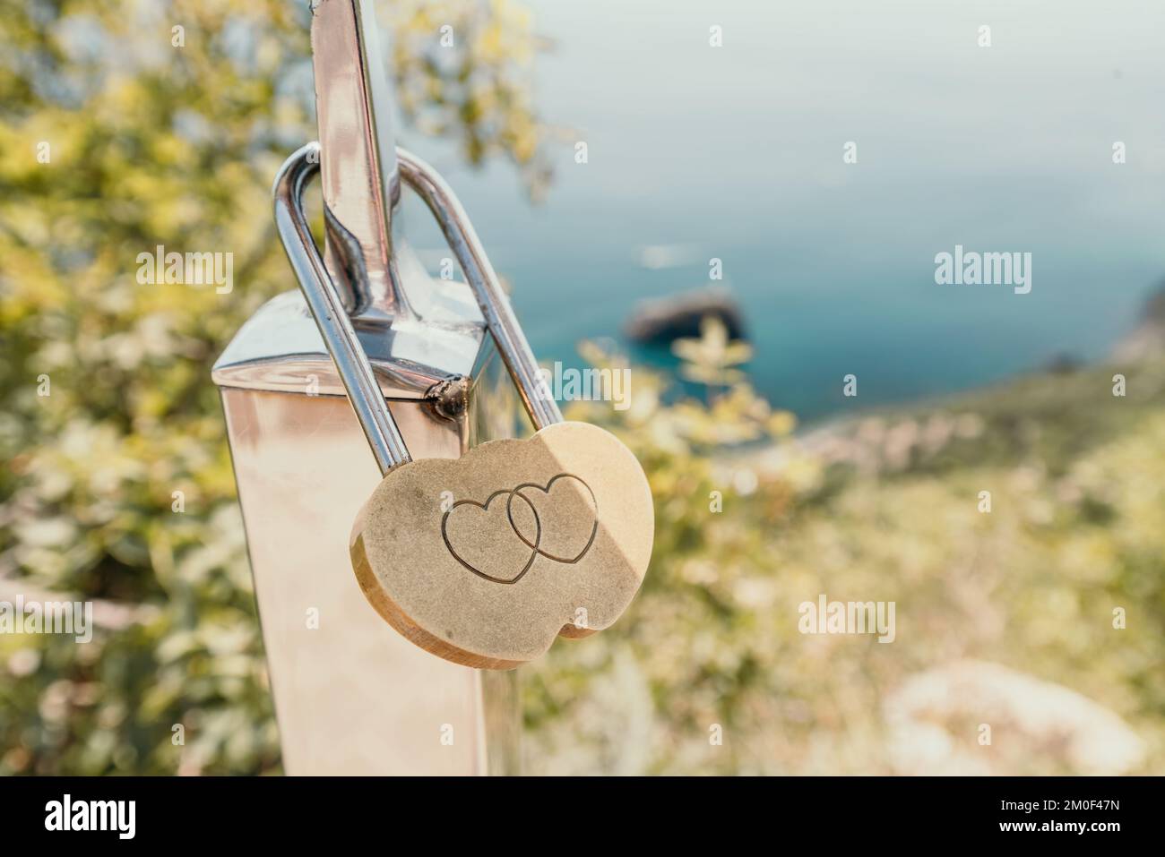 Wedding Heart Golden Lock on stainless iron fence. Valentine's day. Symbol of eternal love. A wedding tradition all over the world to hinder the lock Stock Photo