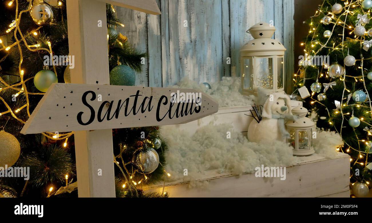 Santa Arrow Sign In Front Of Christmas Toys Near Holiday Tree With Party Illumination Stock Photo