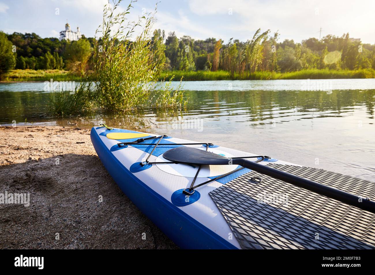 Stand up paddle boards SUP on the beach in the mountain lake Sairan in city Almaty near Orthodox Church in Kazakhstan. Stock Photo