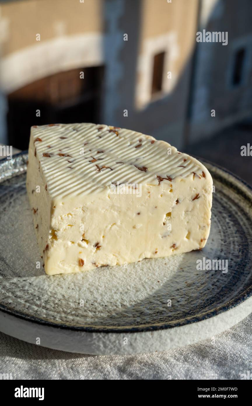 Piece of white sheep cheese with aromatic black cumin seeds served outdoor Stock Photo