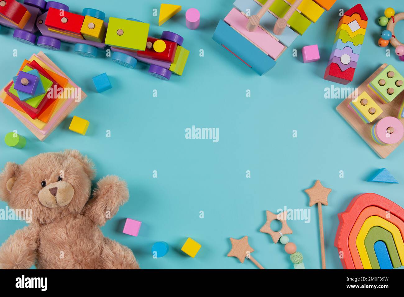 Baby kids toys frame background. Teddy bear, wooden educational