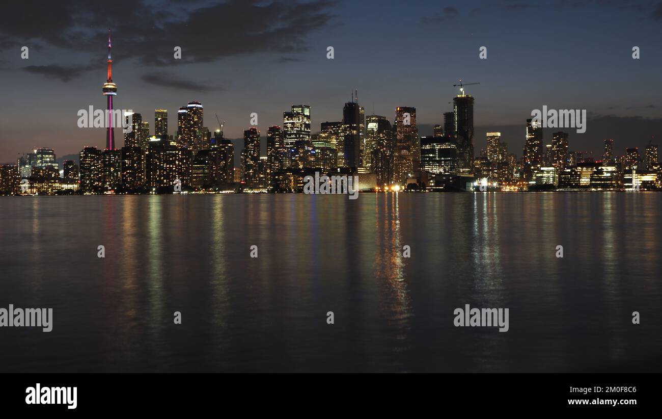 The illuminated Toronto city skyline at the night reflected in waters ...
