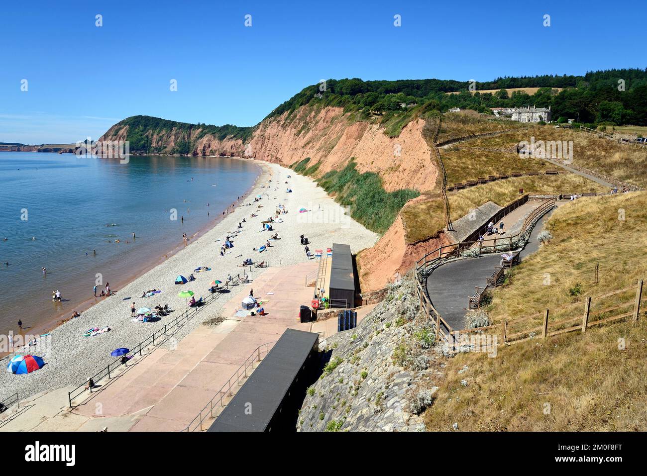 Elevated view of tourists relaxing on Jacobs Ladder beach with cliffs and coastline to the rear, Sidmouth, Devon, UK, Europe. Stock Photo