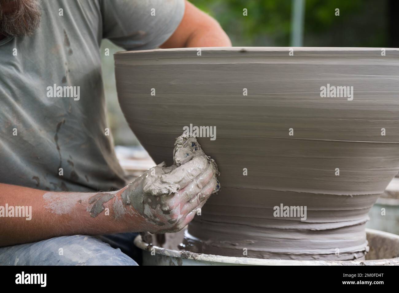 Hands of a man making a clay vase on a potter's wheel Stock Photo