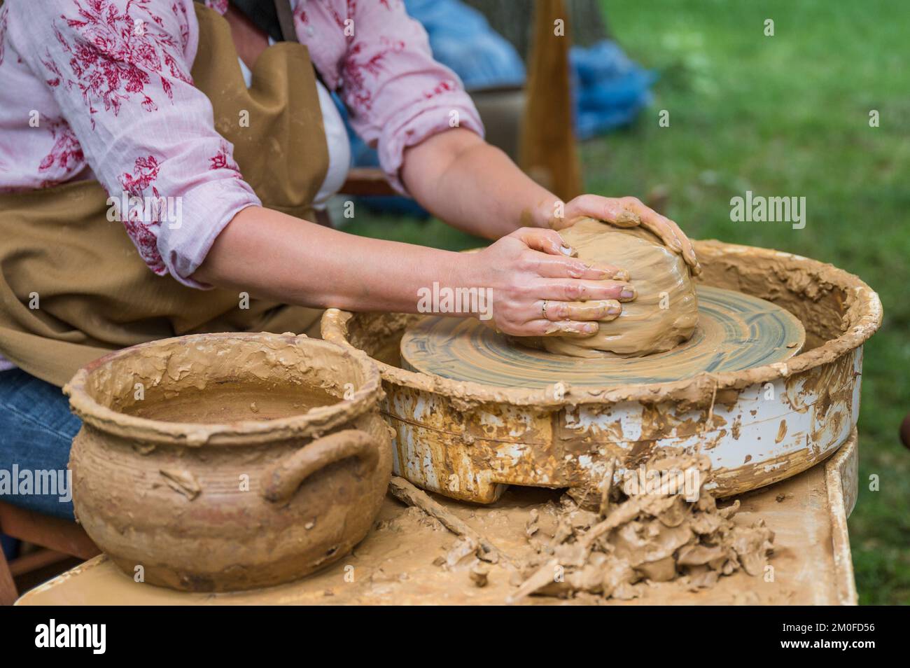 Hands of a woman making a clay pot on a potter's wheel Stock Photo