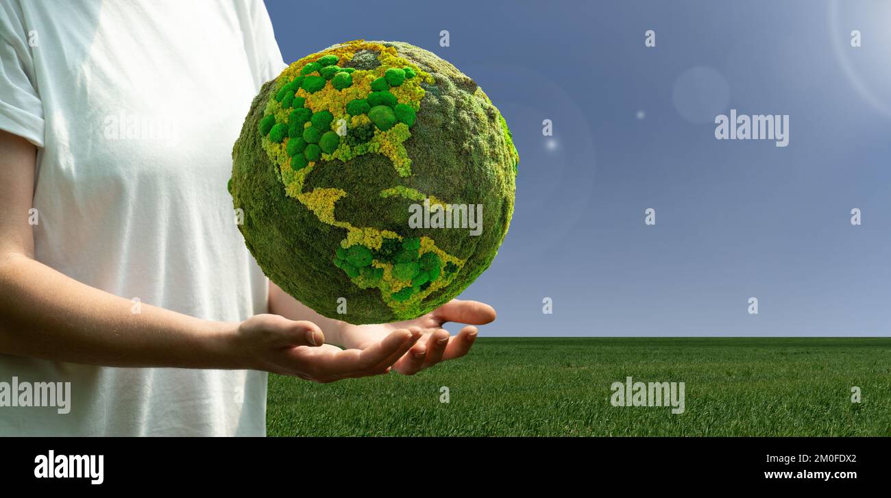 Woman holding a green planet Earth. Symbol of sustainable development Stock Photo