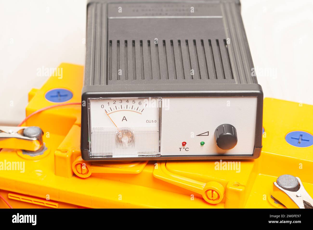 yellow car battery with car battery charger Stock Photo Alamy