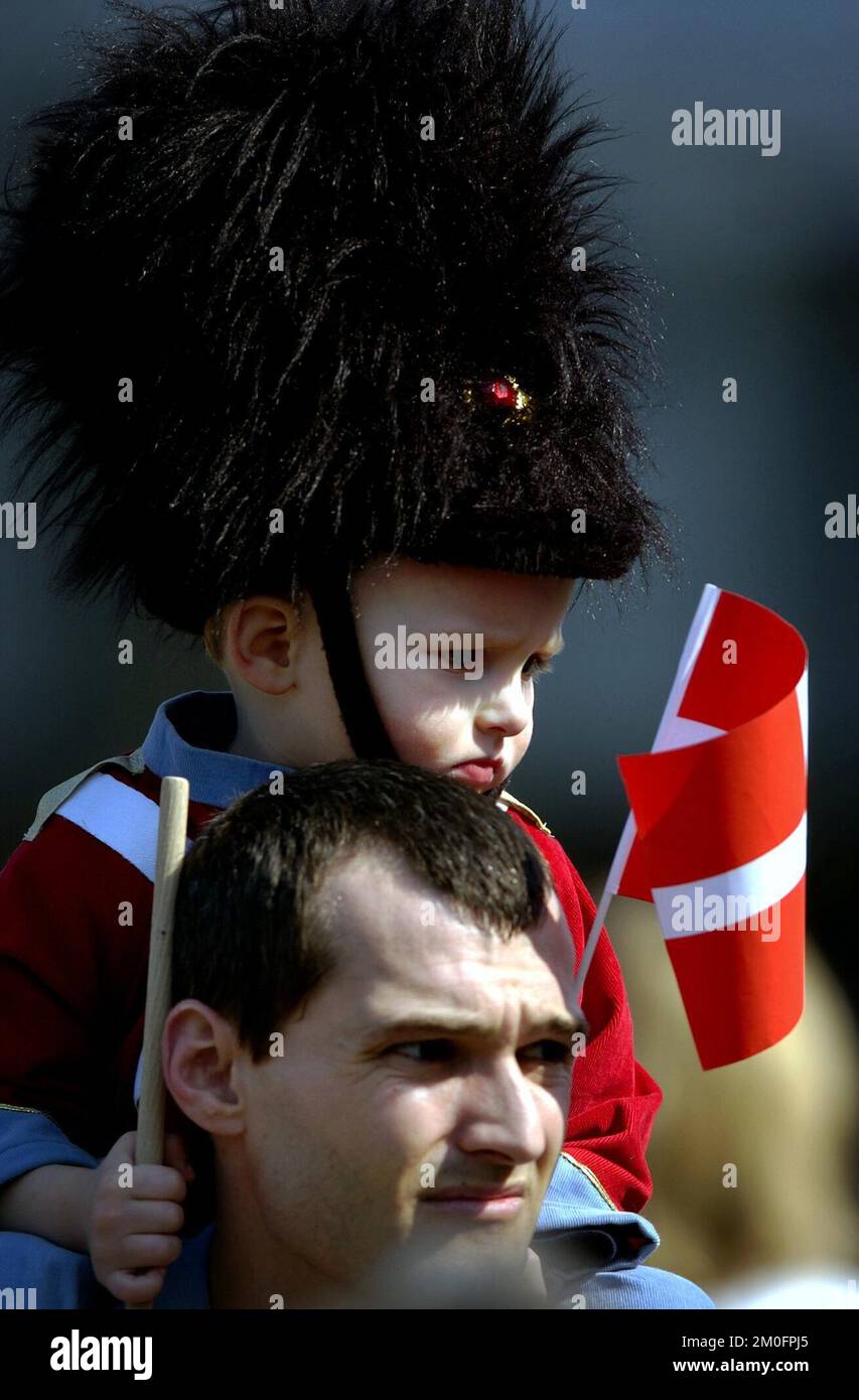 A little boy sits on his fathers shoulders in celebration of Queen Margrethe's birthday.  The Queen celebrated her birthday and waved to the crowd who had gathered at Amalienborg castle, the residence of the Danish royal family. Stock Photo
