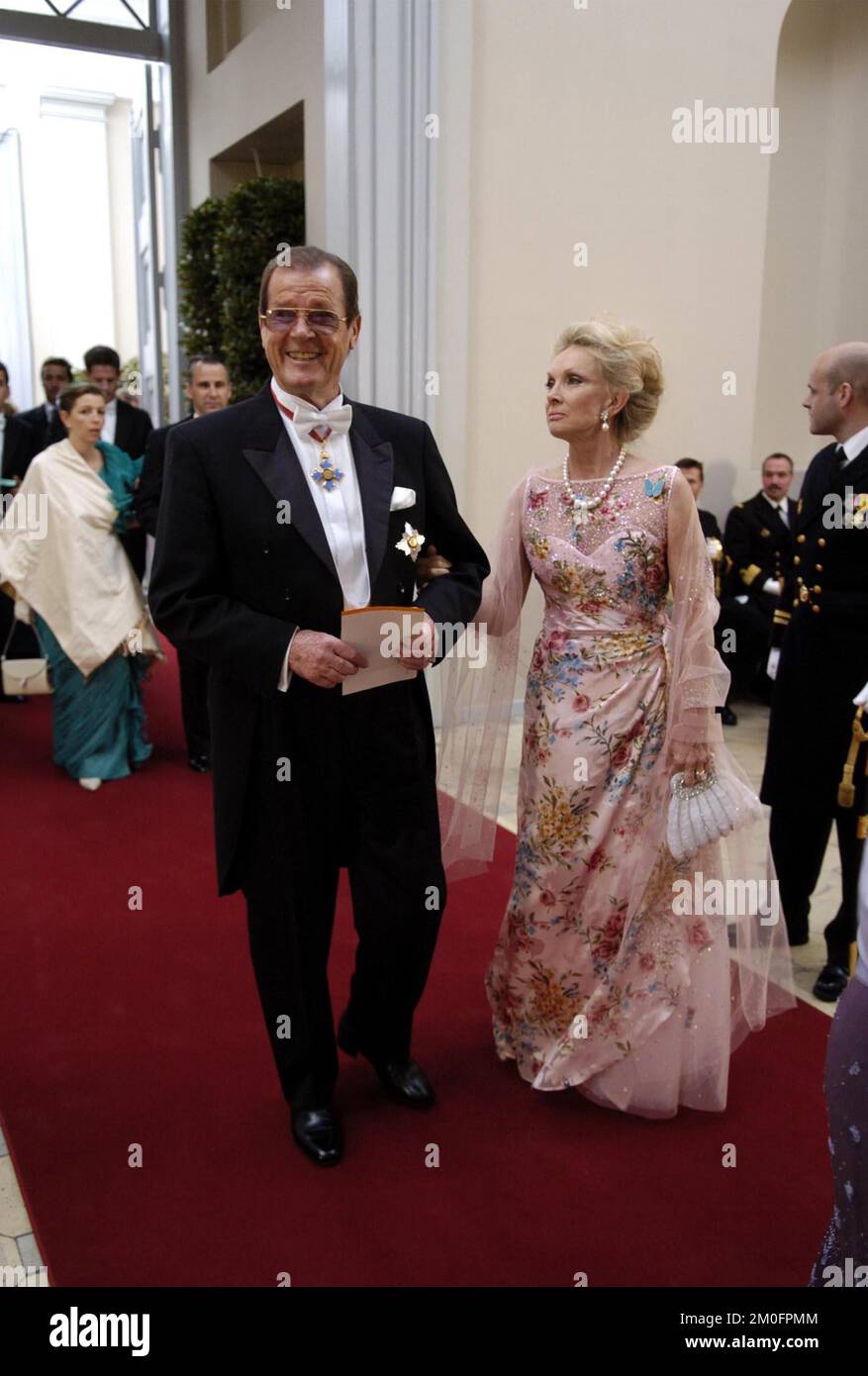 Sir Roger Moore and his wife Kiki Tholstrup arrive to the Royal Wedding at the Copenhagen Cathedral, The Church of Our Lady, where The Danish Crown Prince Frederik will marry Miss Mary Donaldson. Stock Photo