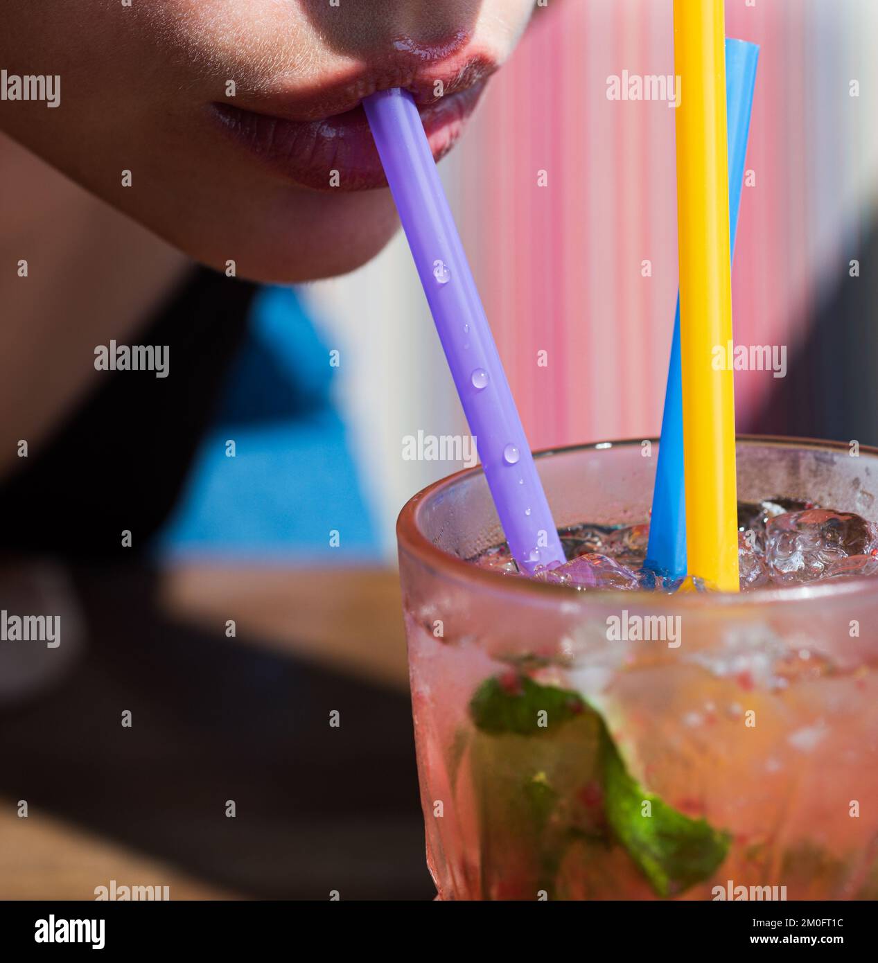 Close up straw in mouth. Summer juice cocktail drink. Straw in lips