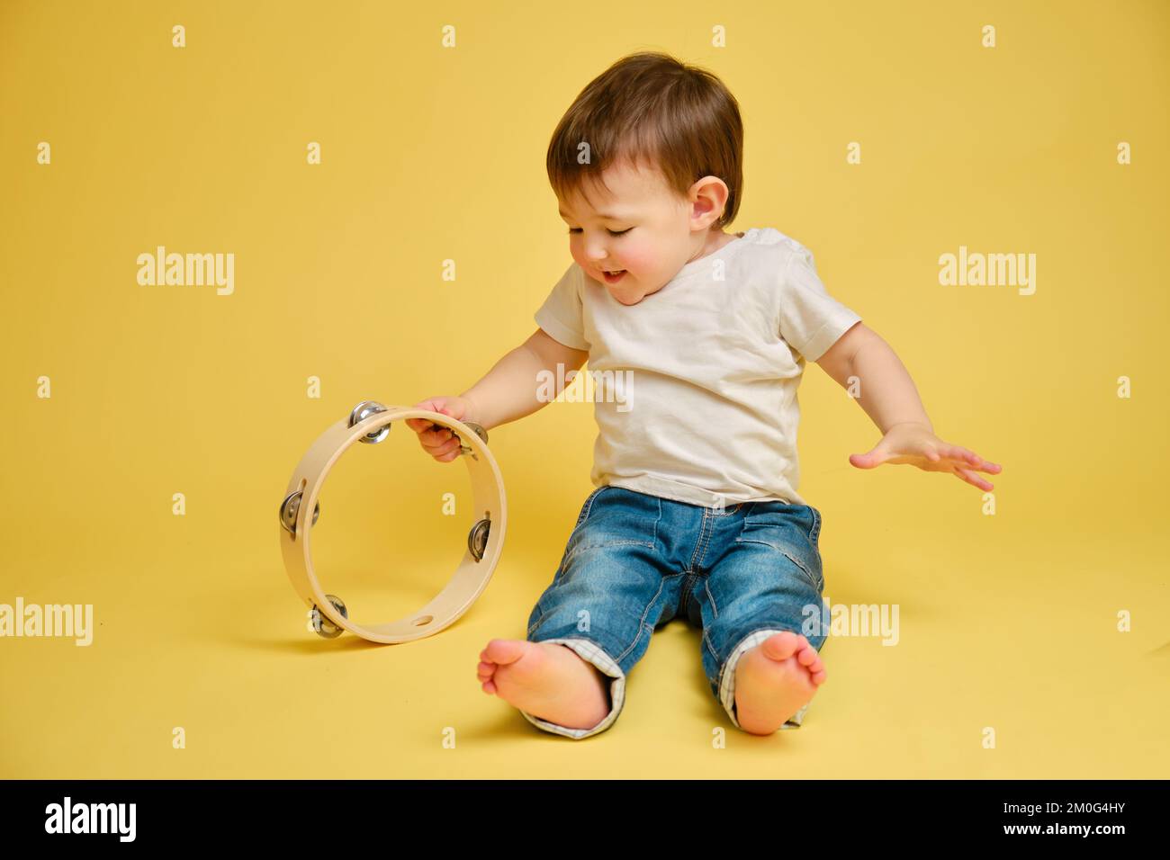 Toddler baby plays the tambourine, a child with a percussion musical