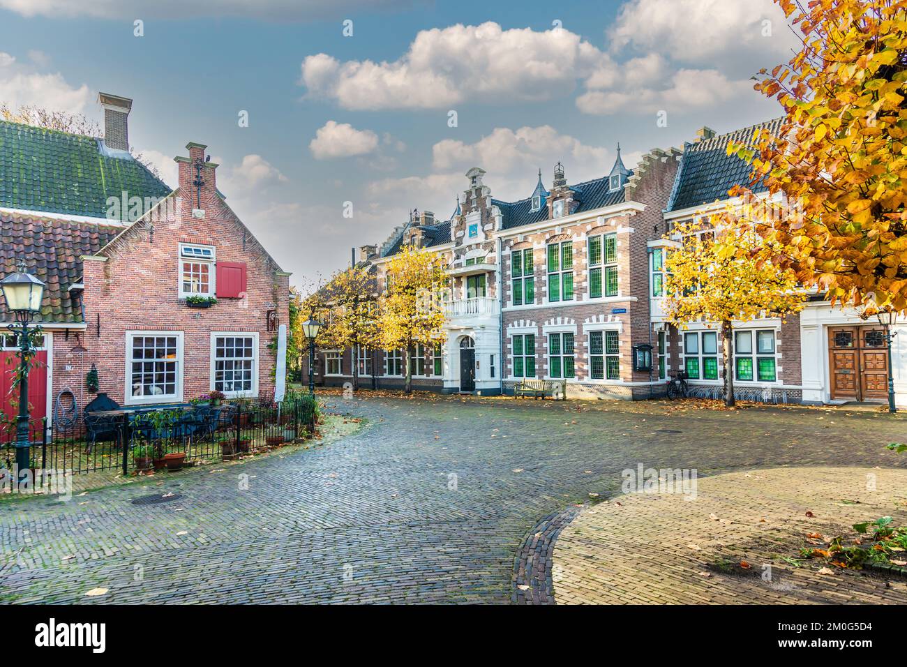 Street view during sunrise of historic houses in Hoofdbuurtstraat in Oud Velsen in the Dutch province of North Holland Stock Photo