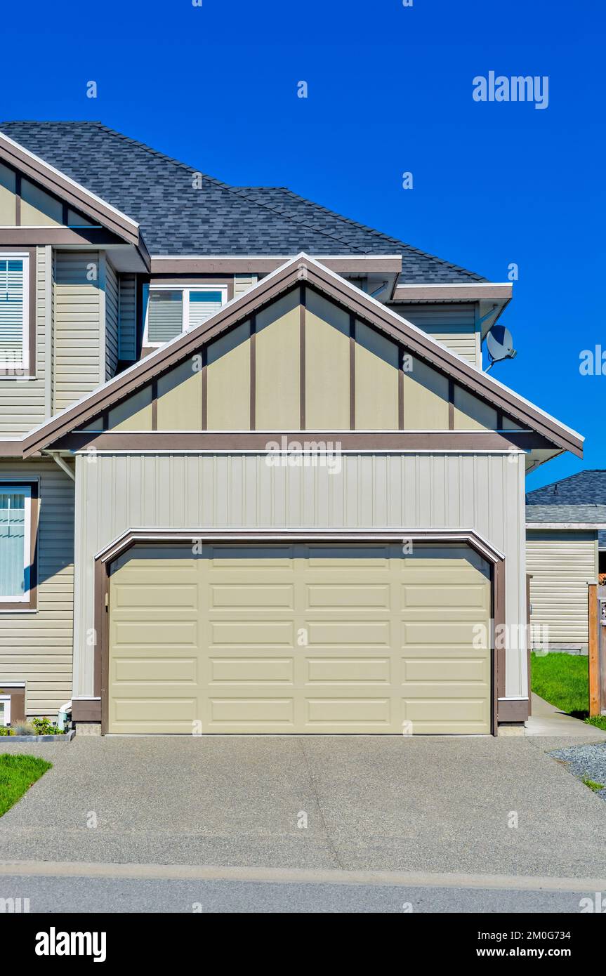Double wide garage door of residential house with concrete driveway in front Stock Photo Alamy
