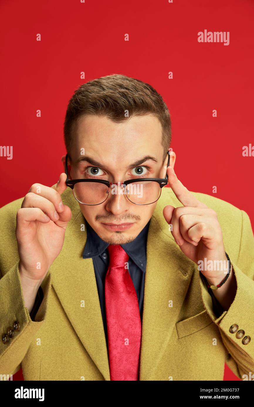Portrait of young man in stylish jacket and glasses posing, looking