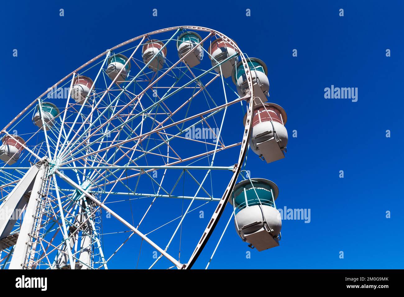 Ferris wheel is under clear blue sky on a sunny day Stock Photo