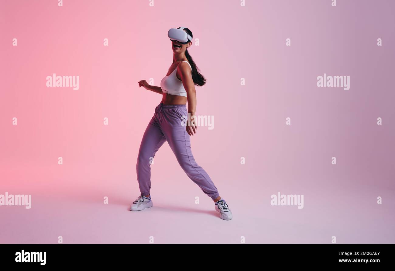 Happy young woman dancing in the metaverse. Active young woman laughing ...