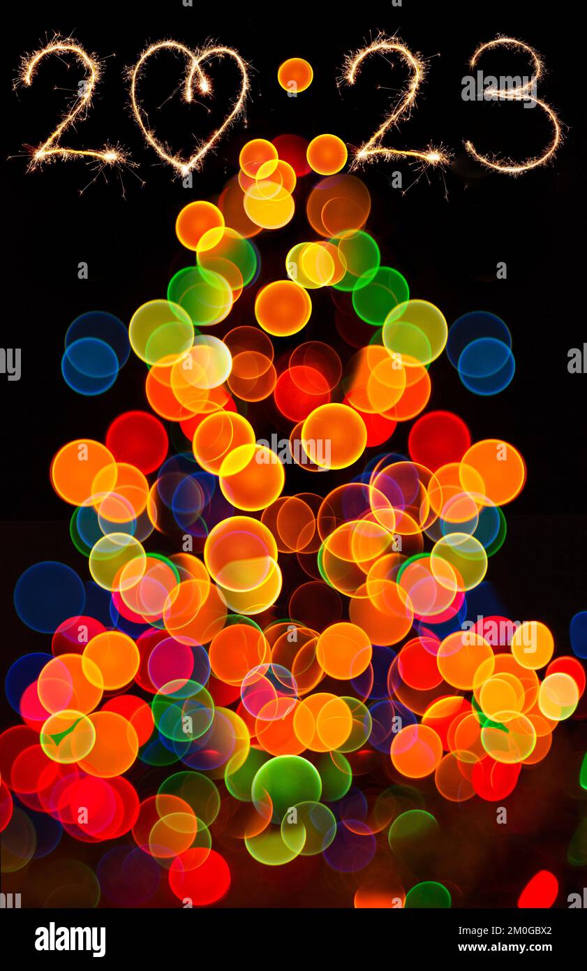 Abstract circular bokeh of Christmaslight. Bokeh lights on black background. Happy new year 2023 and christmas tree. Stock Photo