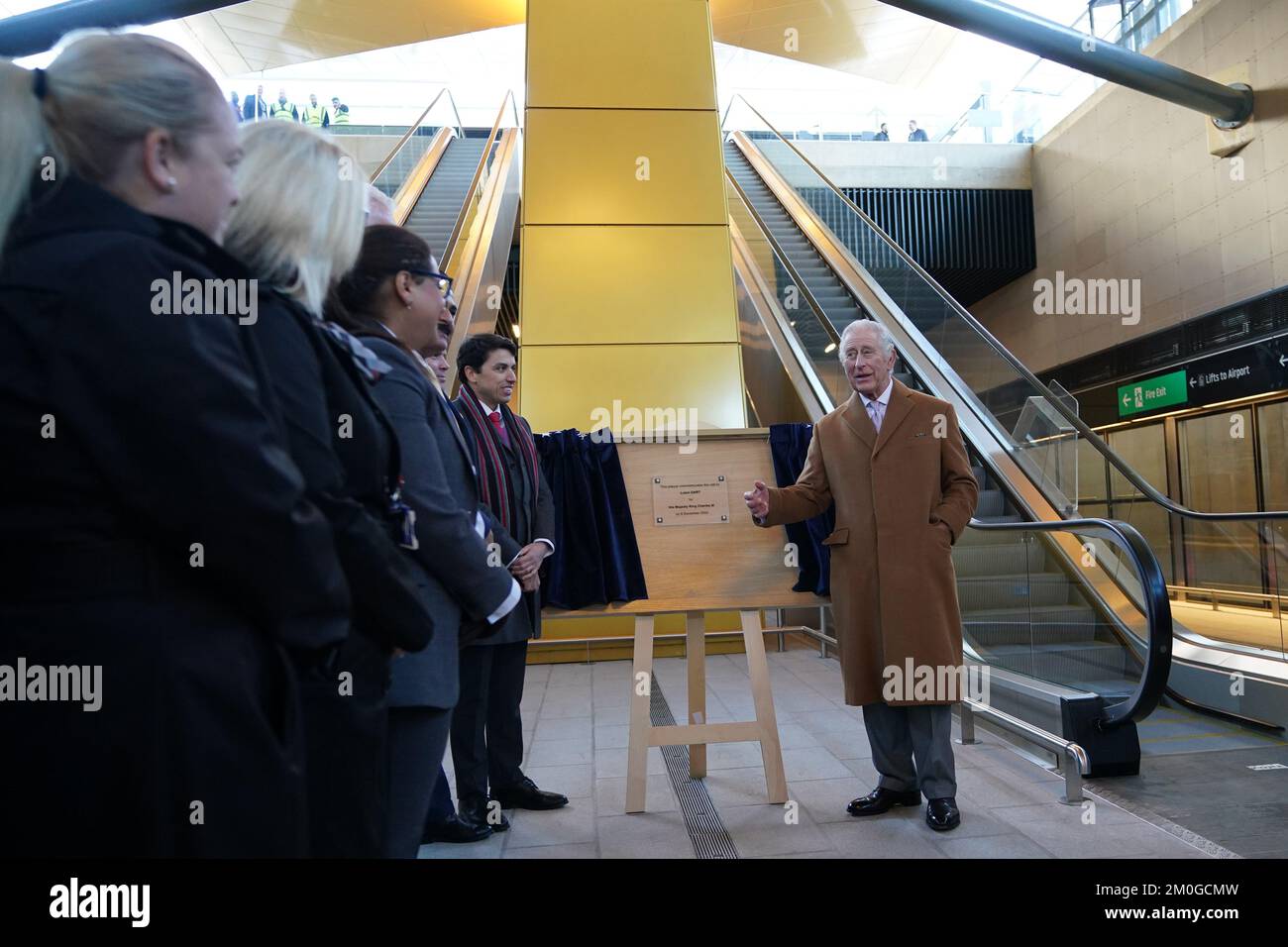 King Charles III unveils a plaque during a visit to Luton Airport to