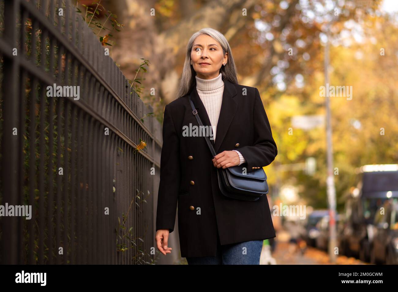 Pretty mature woman walking in the autumn park Stock Photo