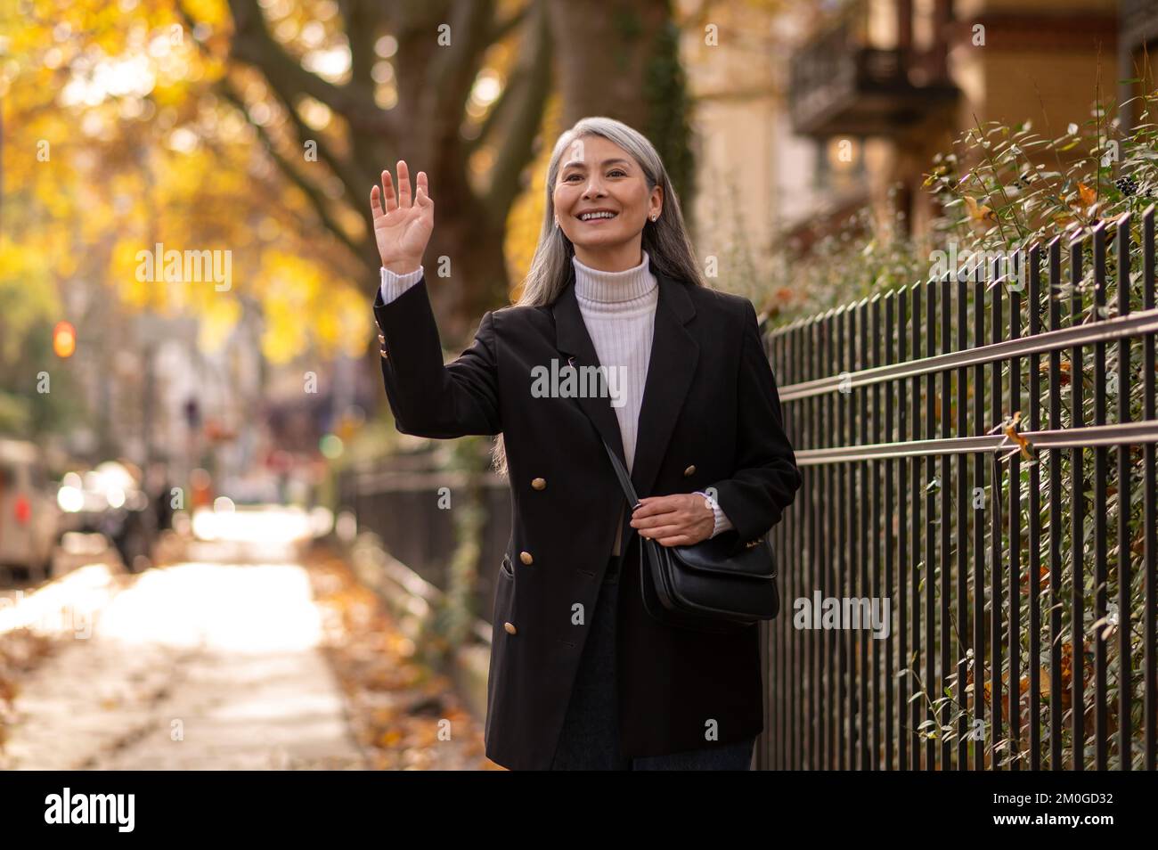 Pretty mature woman walking in the autumn park Stock Photo