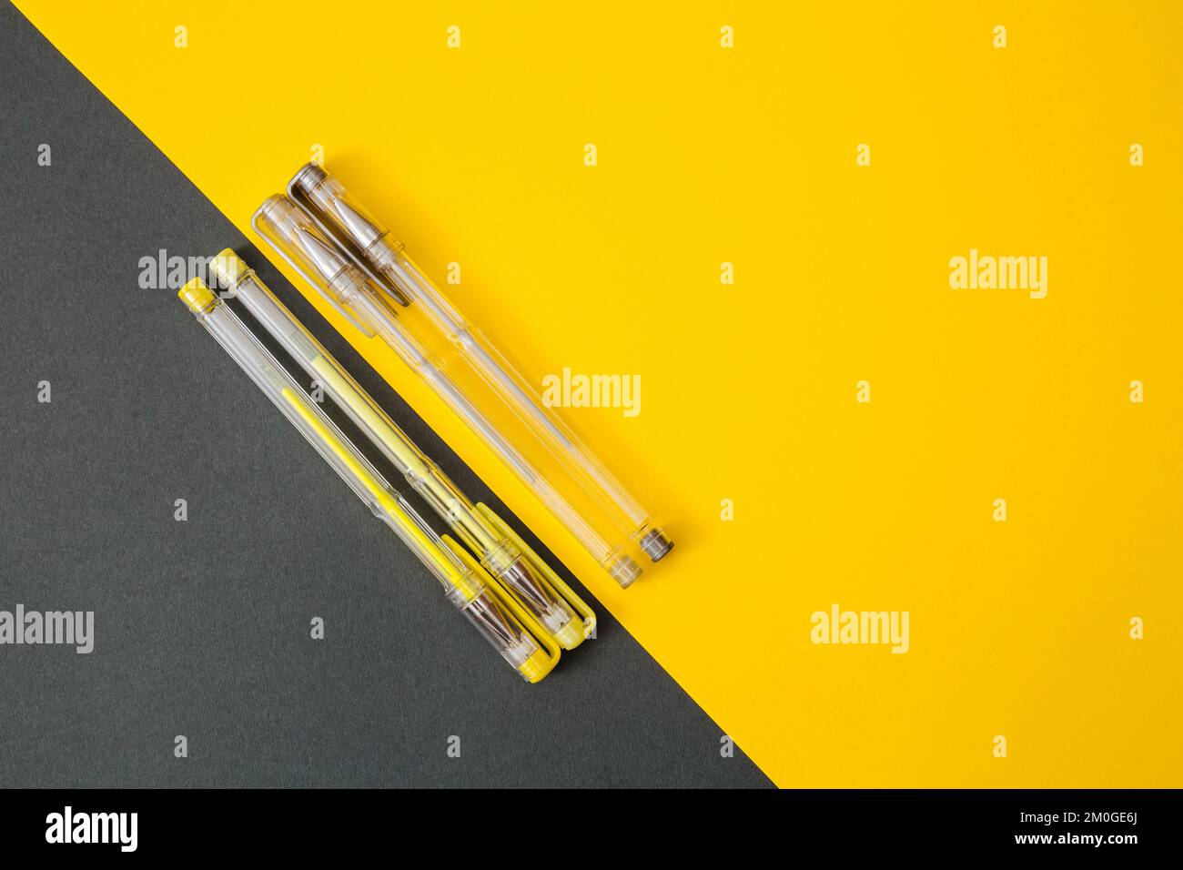 Yellow and gray gel pens on a yellow and gray background. Stock Photo