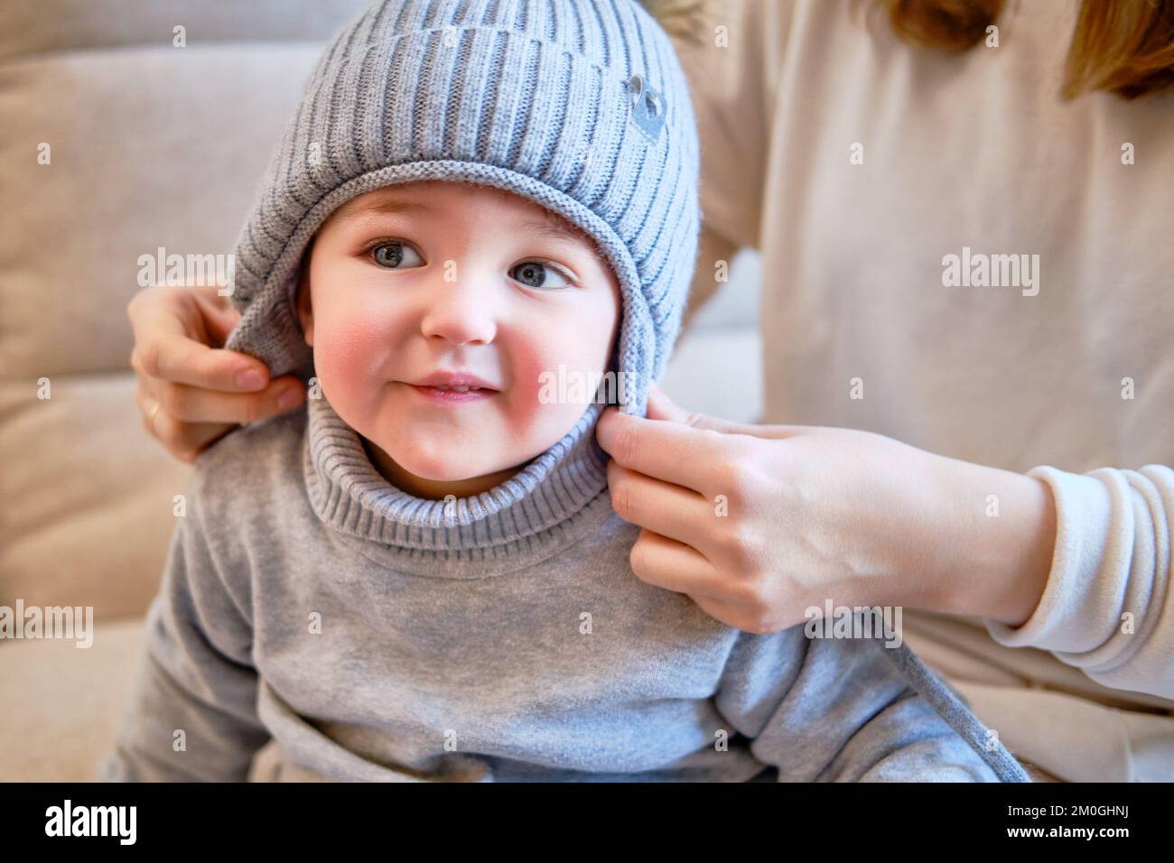 Child is dressed in warm winter clothes for a walk outside. Woman