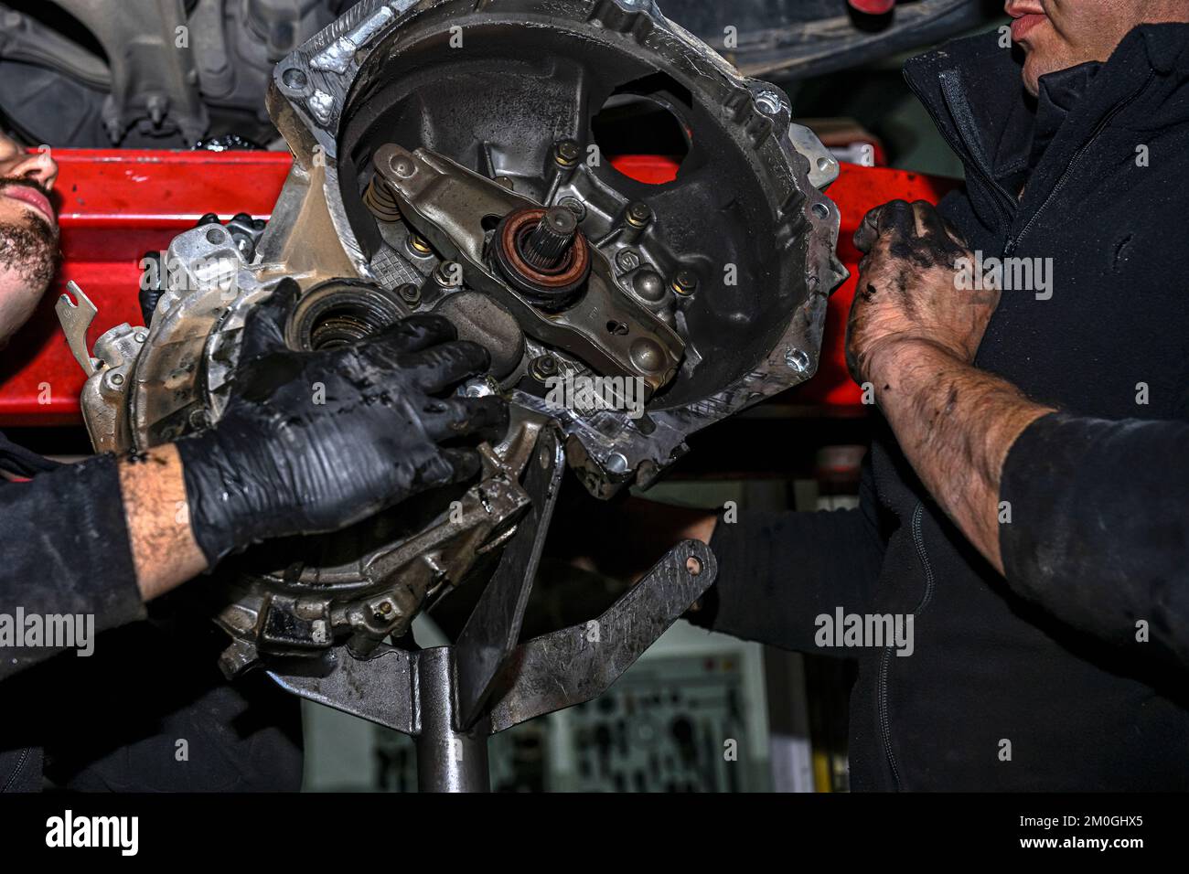 Hands of a mechanic removing the clutch disc from a vehicle Stock Photo