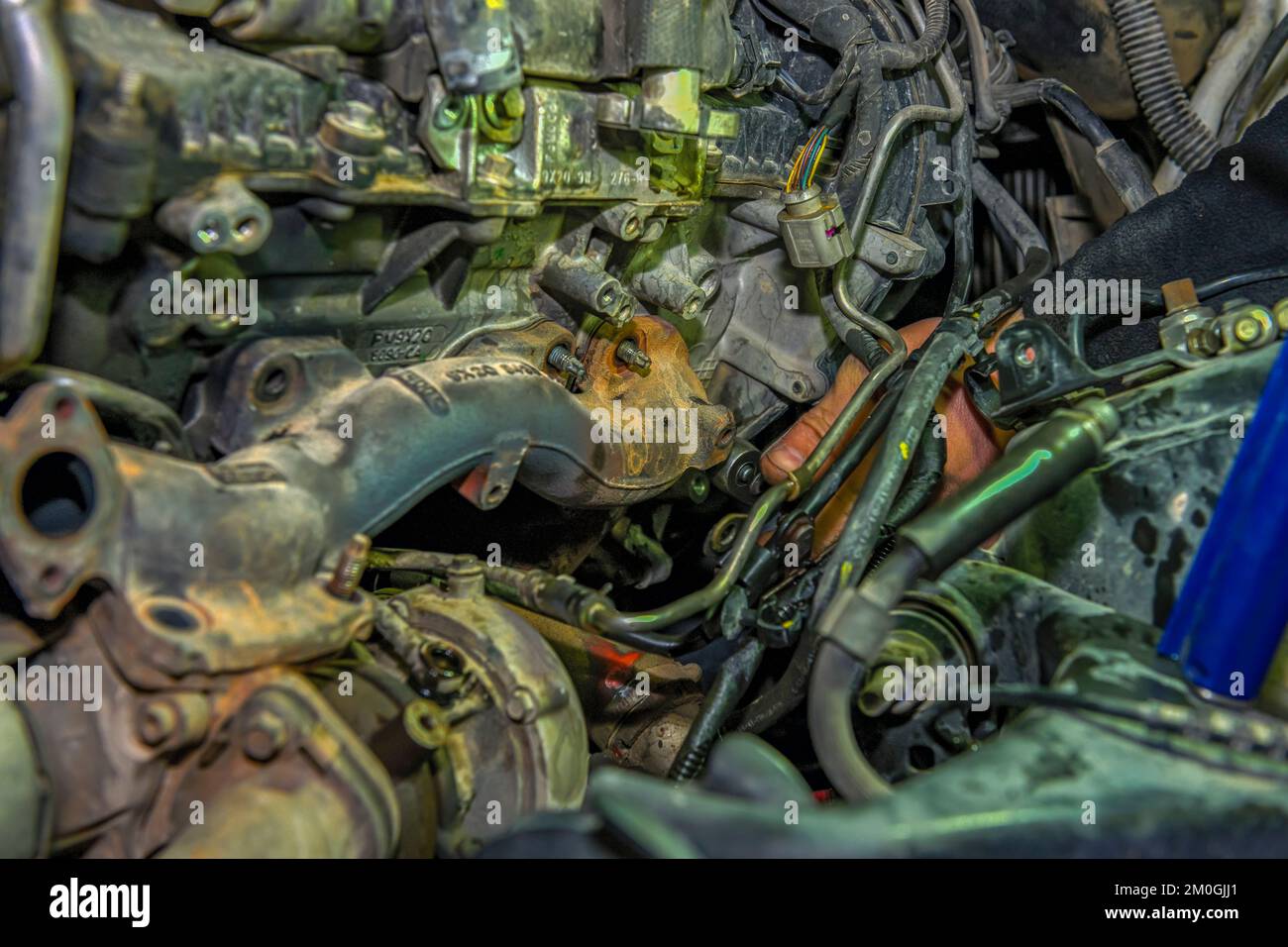 Auto mechanic repairing the exhaust manifold of a car engine Stock