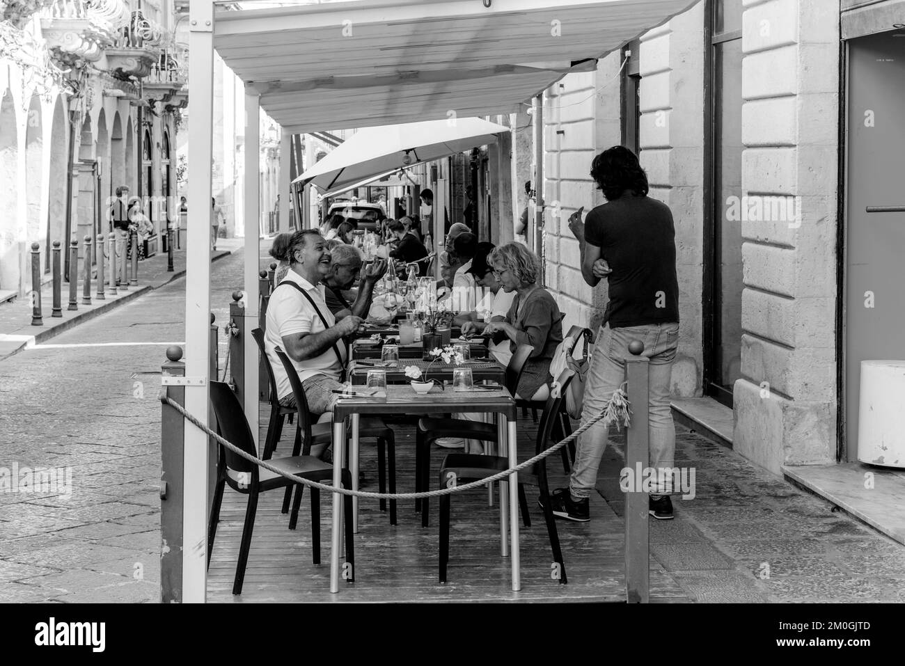 Customers Sitting Down Eating Lunch Outside A Restaurant In Ortigia