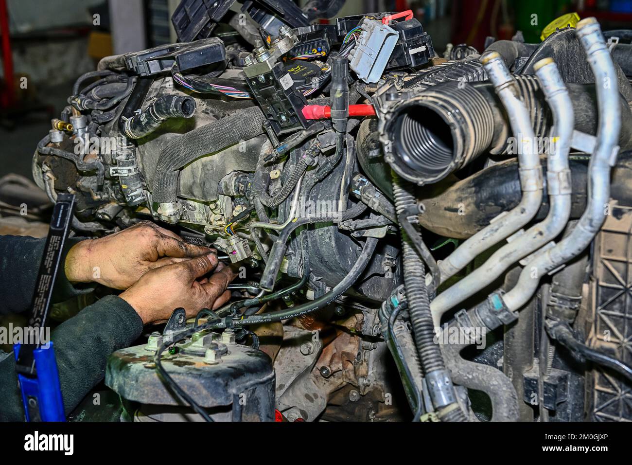 Auto mechanic repairing the exhaust manifold of a car engine Stock