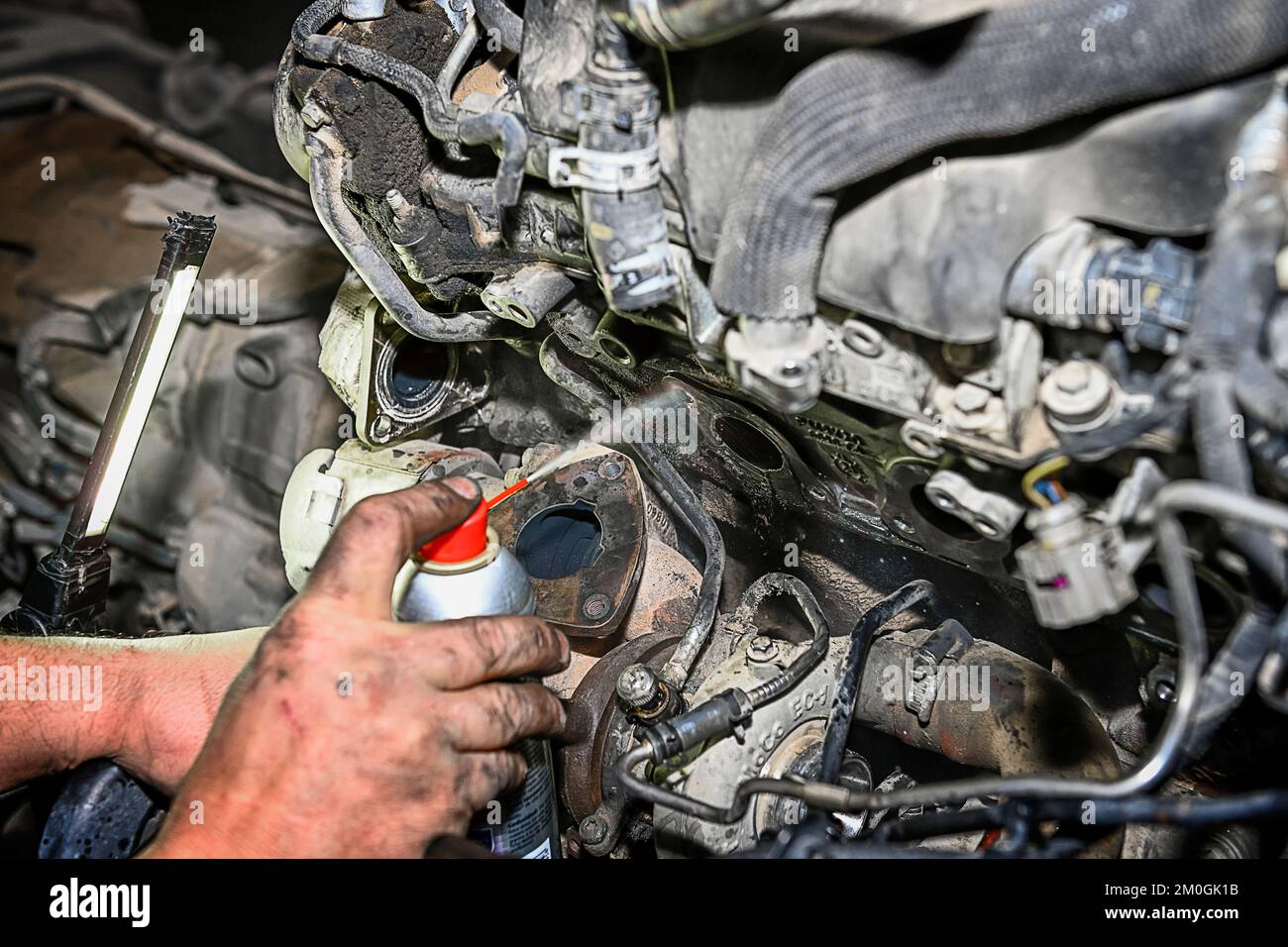 Auto mechanic repairing the exhaust manifold of a car engine Stock