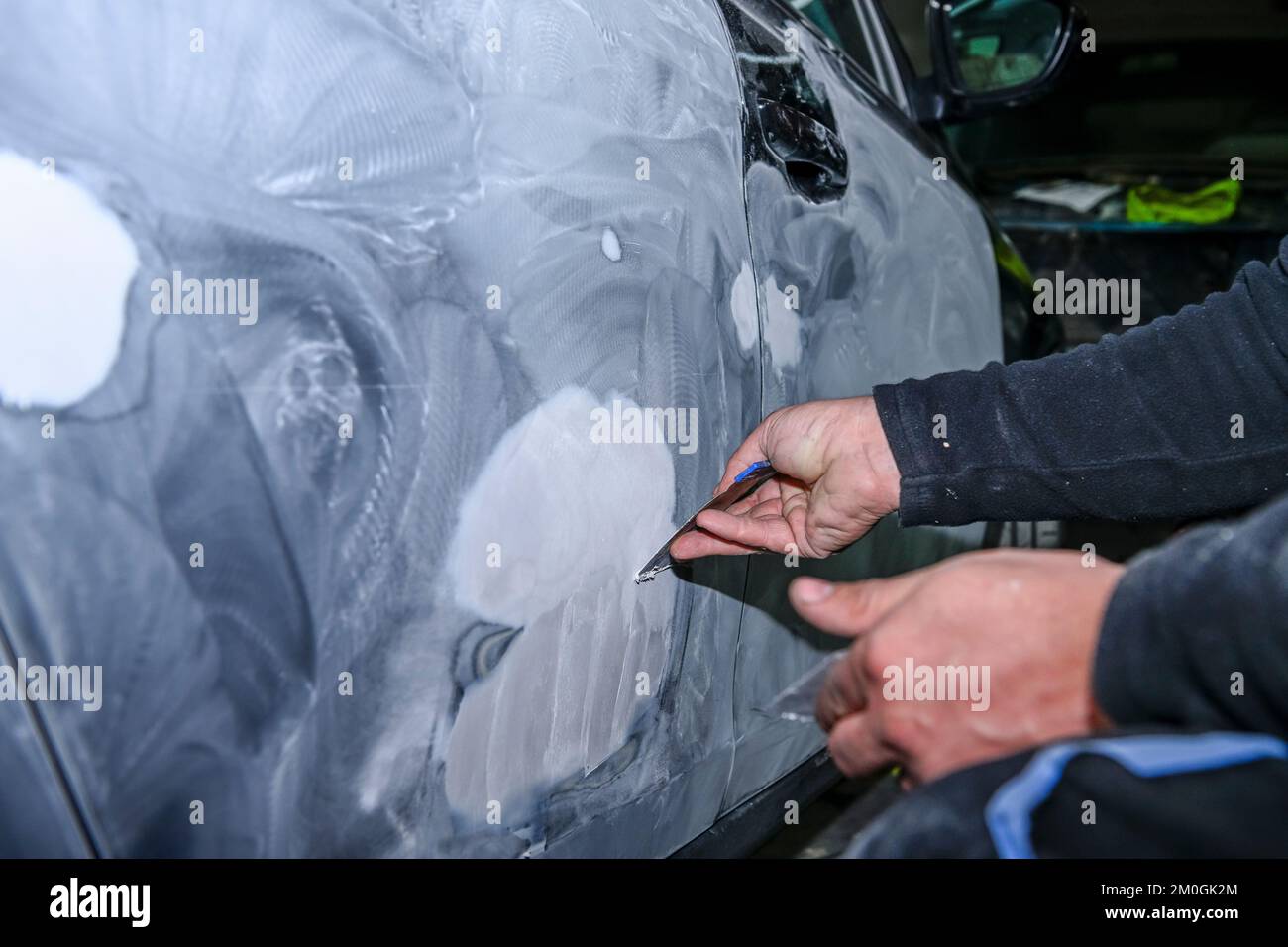Sheet metal worker, modeling with putty, the body of a car Stock Photo