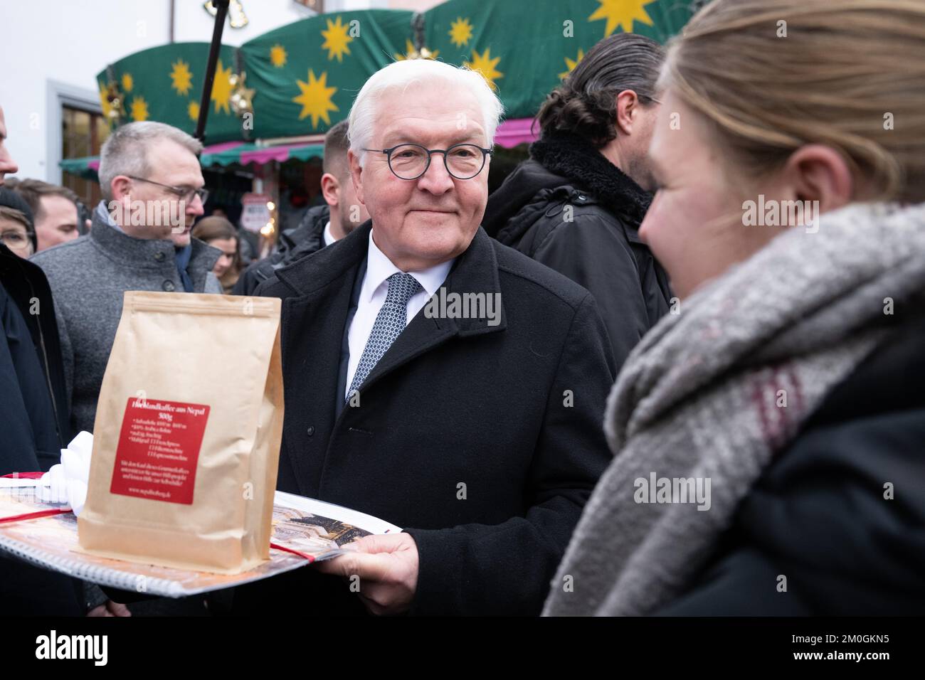 Freiberg, Germany. 06th Dec, 2022. Federal President Frank-Walter Steinmeier receives a gift of coffee from Nepal and a calendar from schoolchildren at the Christmas market. The Federal President moves his official residence to Freiberg for three days to talk to citizens, entrepreneurs and local politicians about their everyday lives and current problems. Credit: Sebastian Kahnert/dpa/Alamy Live News Stock Photo