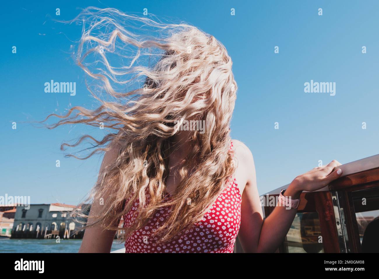 Girl's hair blowing in the wind on a speedboat, Venice Stock Photo