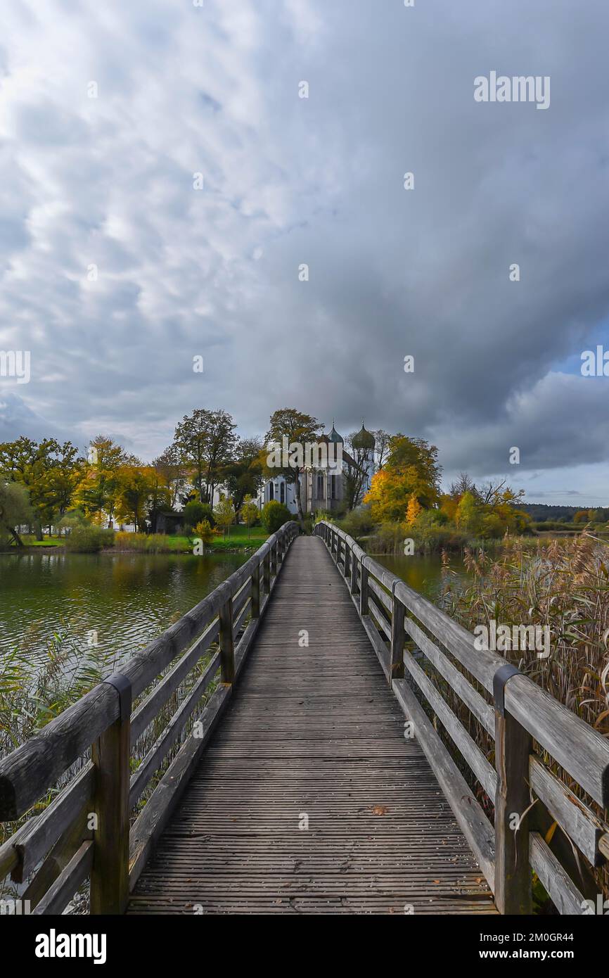 Seeon Monastery with St. Lambert's Monastery Church, in front a wooden bridge over the Klostersee, Seeon, Chiemgau, Bavaria, Germany, Europe Stock Photo