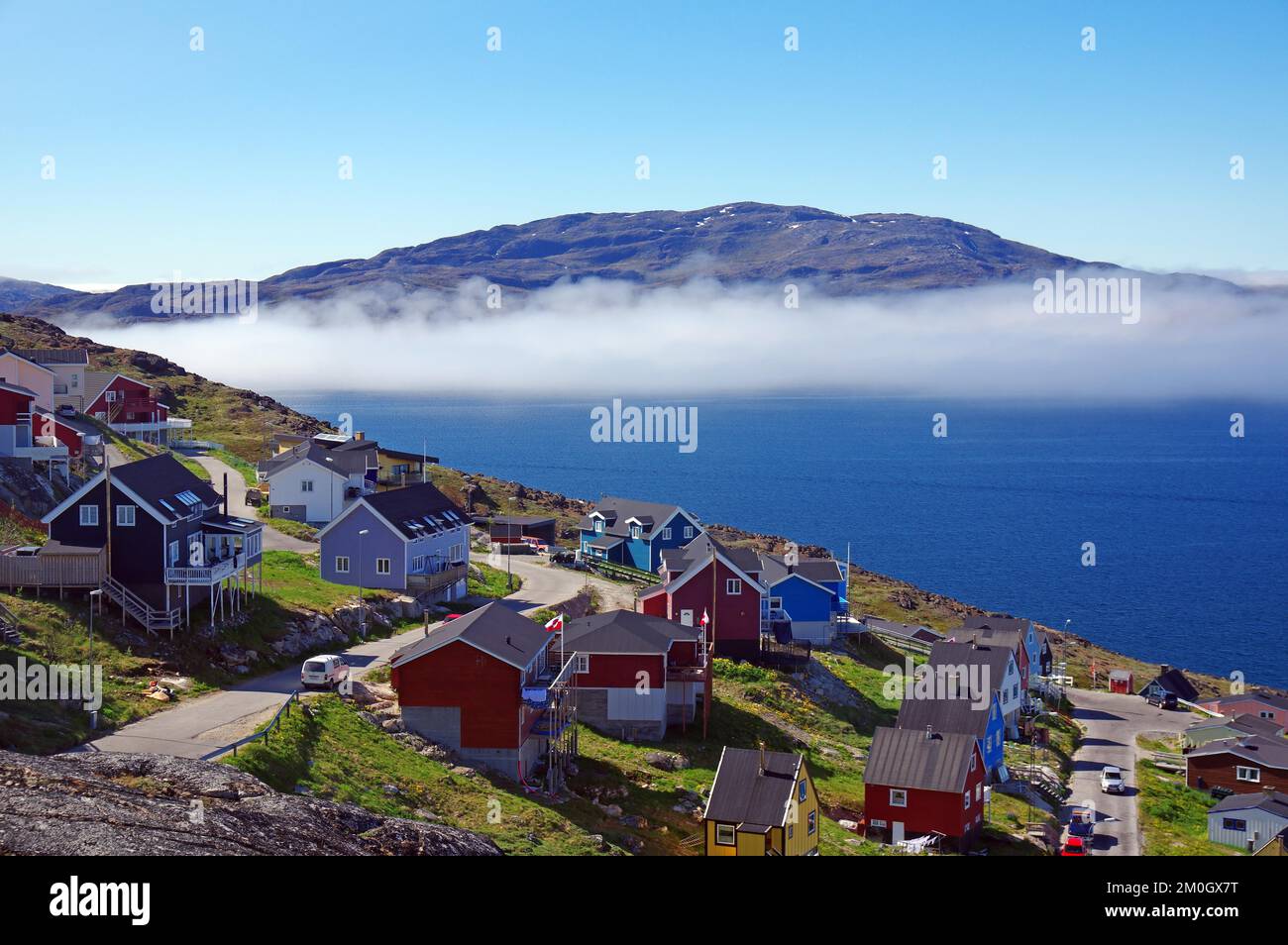 Colourful houses on a residential street, barren mountains in coastal