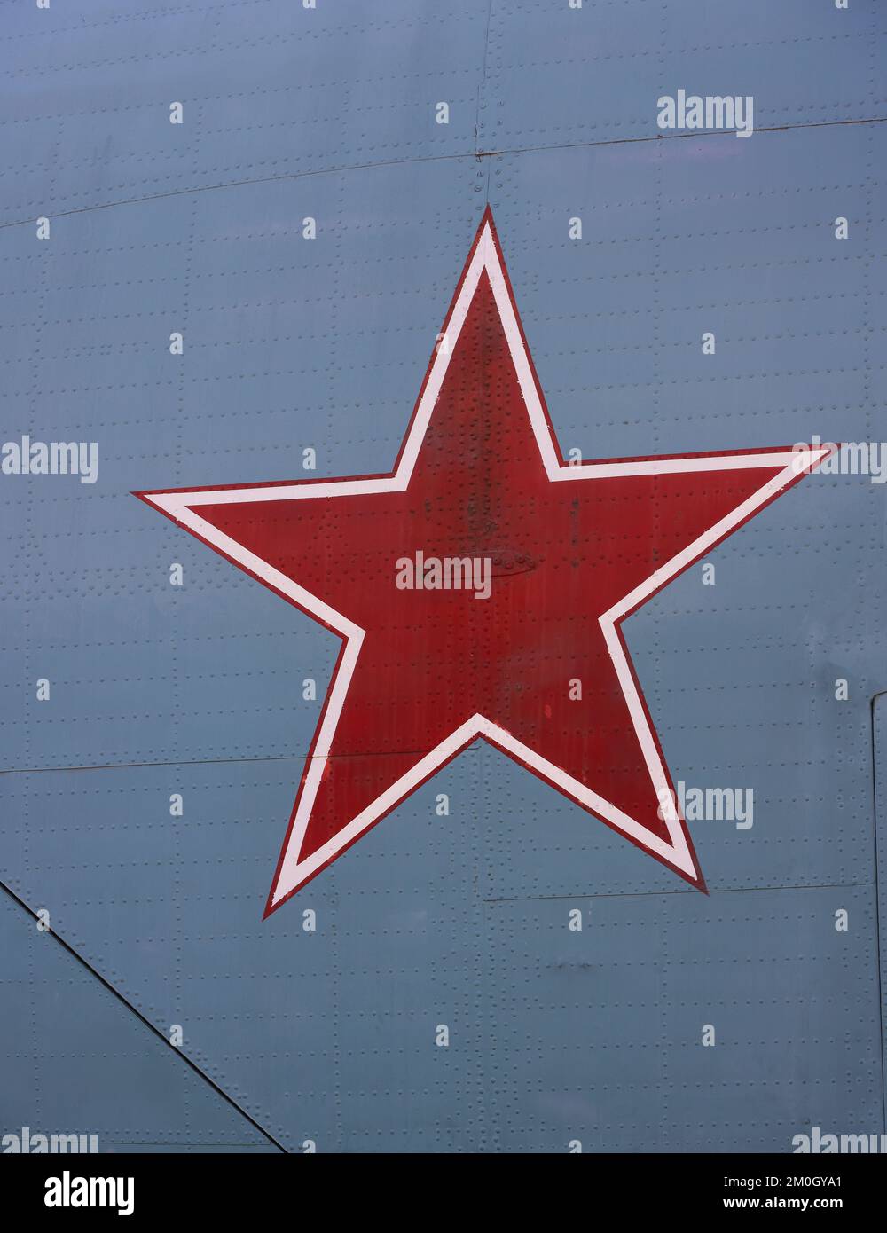 Close up Soviet Union or Russian red star symbol painted on vintage military fighter aircraft studded metal surface Stock Photo