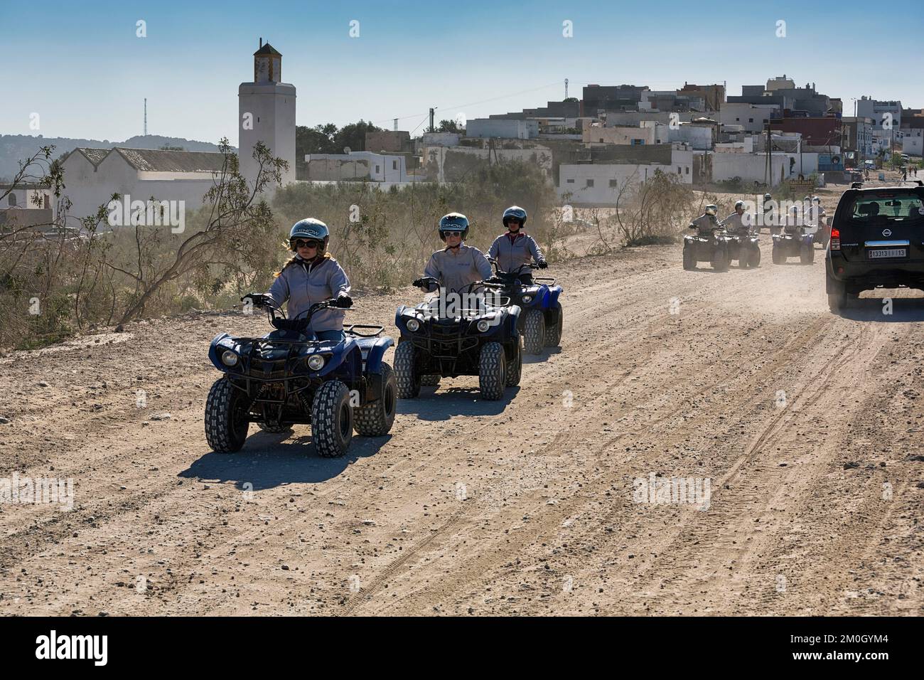 Young quad riders, tourist group on gravel road, Diabat, Essaouira, Morocco, Africa Stock Photo