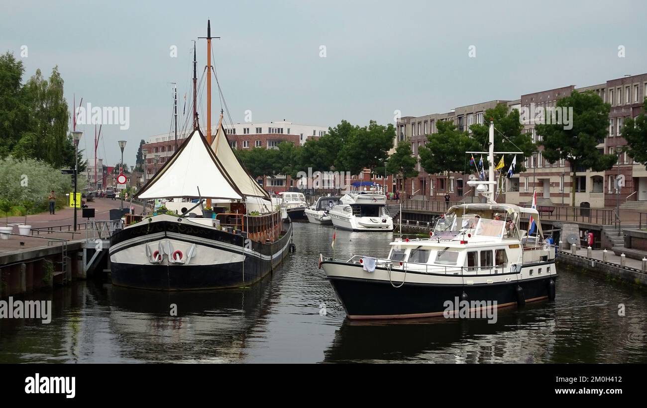 Amersfoort, Netherlands - July 23 2016 A small yacht is going to moor in the harbor of Amersfoort in front of a restaurant ship Stock Photo