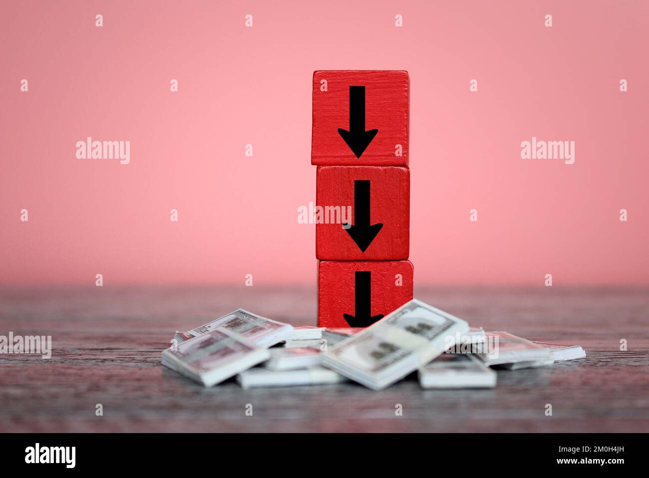 Stack of money and downward arrow. Currency depreciation, economic recession and depression concept Stock Photo