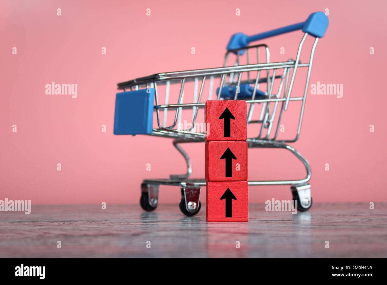 Shopping trolley with red upward arrow. Inflation, rising cost of
