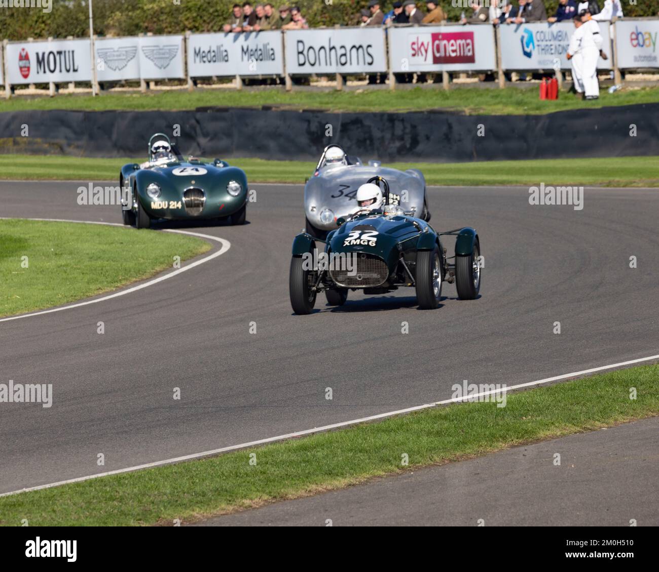 1950 Frazer Nash Replica No. 32 is followed closely 1954 Cooper-Jaguar T33 No.34 with 1954 Jaguar C-type in the rear at the 2022 Goodwood Revival Stock Photo