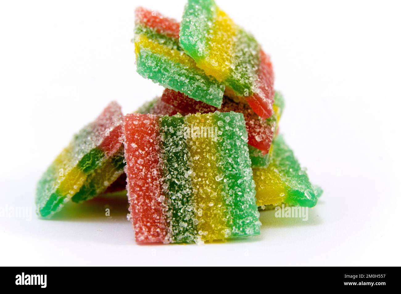 Rainbow stripes of sour jelly candies in sugar sprinkles on a white