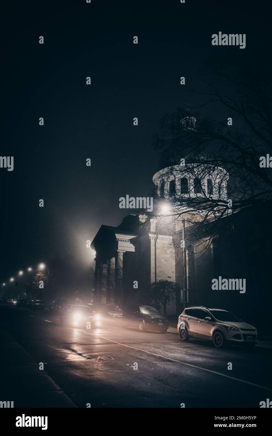 Car driving through a city street on a foggy autumn night Stock Photo ...